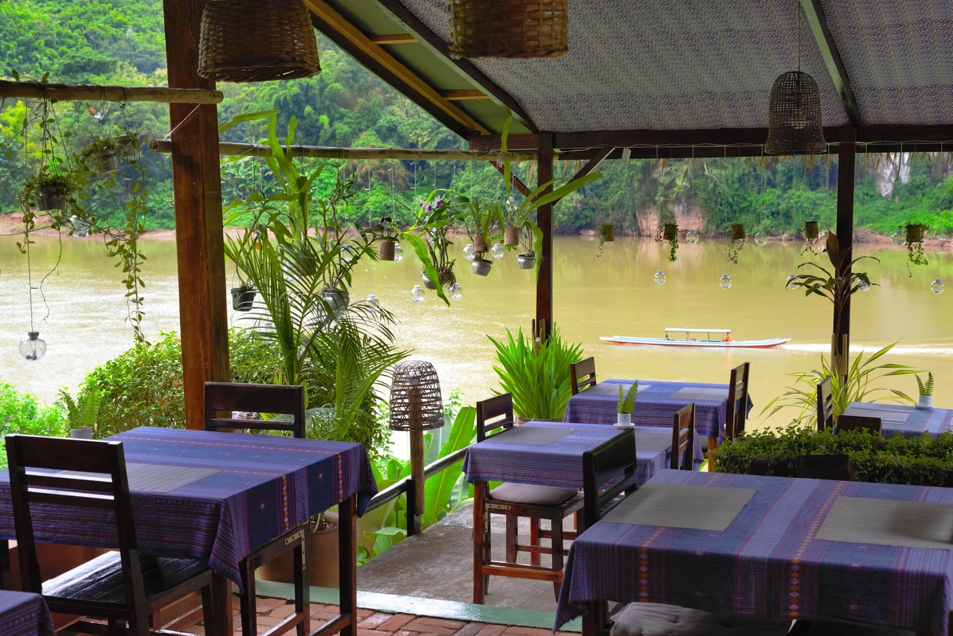 Riverside restaurant pavilion with bamboo architecture and Nam Ou river views