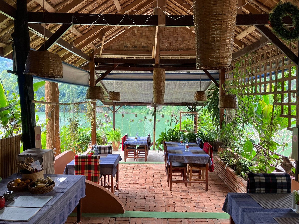 Restaurant dining setup with panoramic Nam Ou river and mountain backdrop